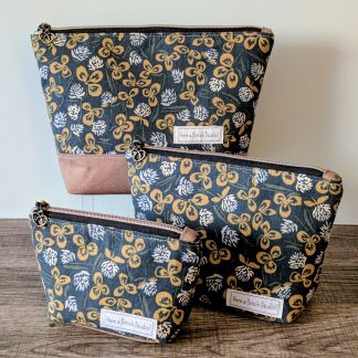 Three sizes of blue and brown bags sitting on wood surface.