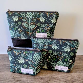 Three bags in different sizes sitting on wooden surface.