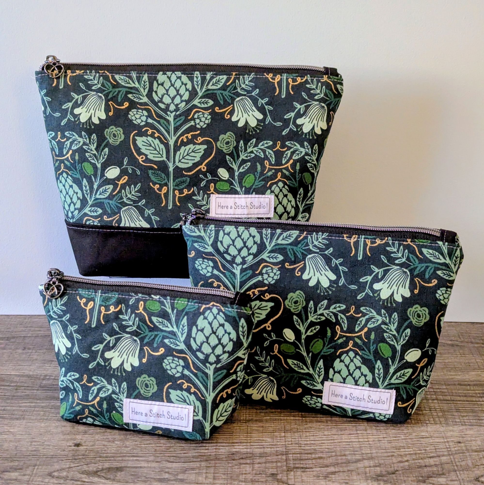 Three bags in different sizes sitting on wooden surface.