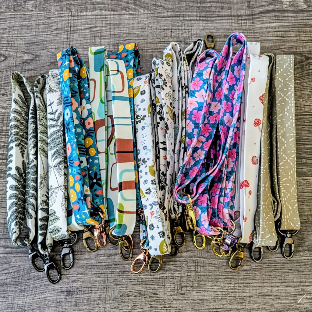 Variety of key chain lanyards laying on wooden surface.
