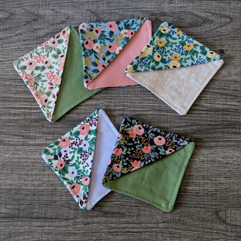 Five corner bookmarks laying on wooden surface.