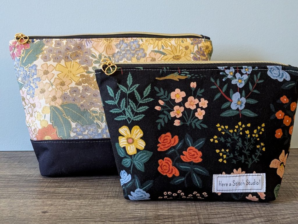 Two floral canvas makeup bags sitting on table.
