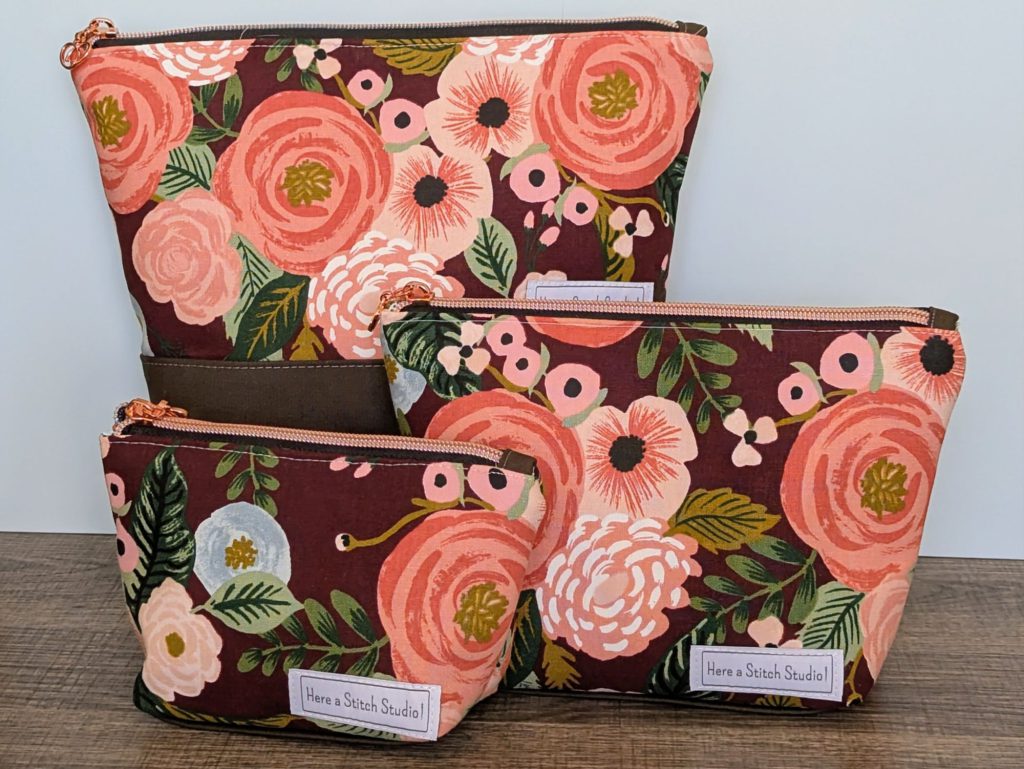 Burgundy floral canvas makeup bags in three sizes.